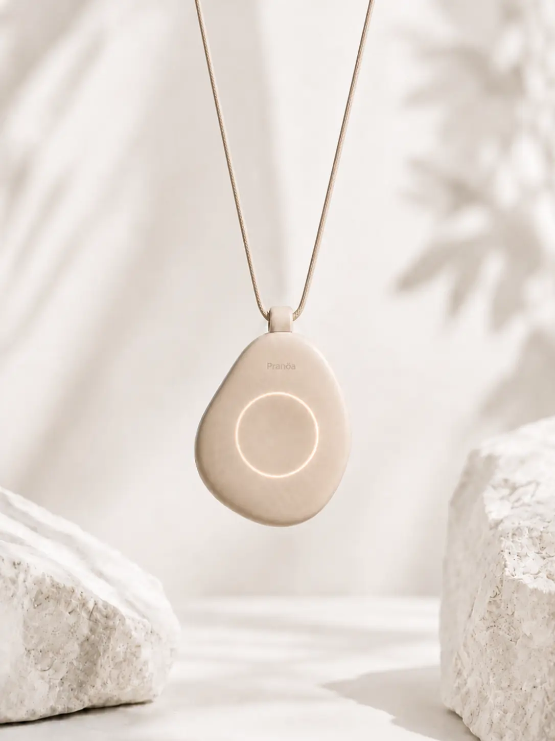 The Pranōa pendant in beige, hanging from its cord
